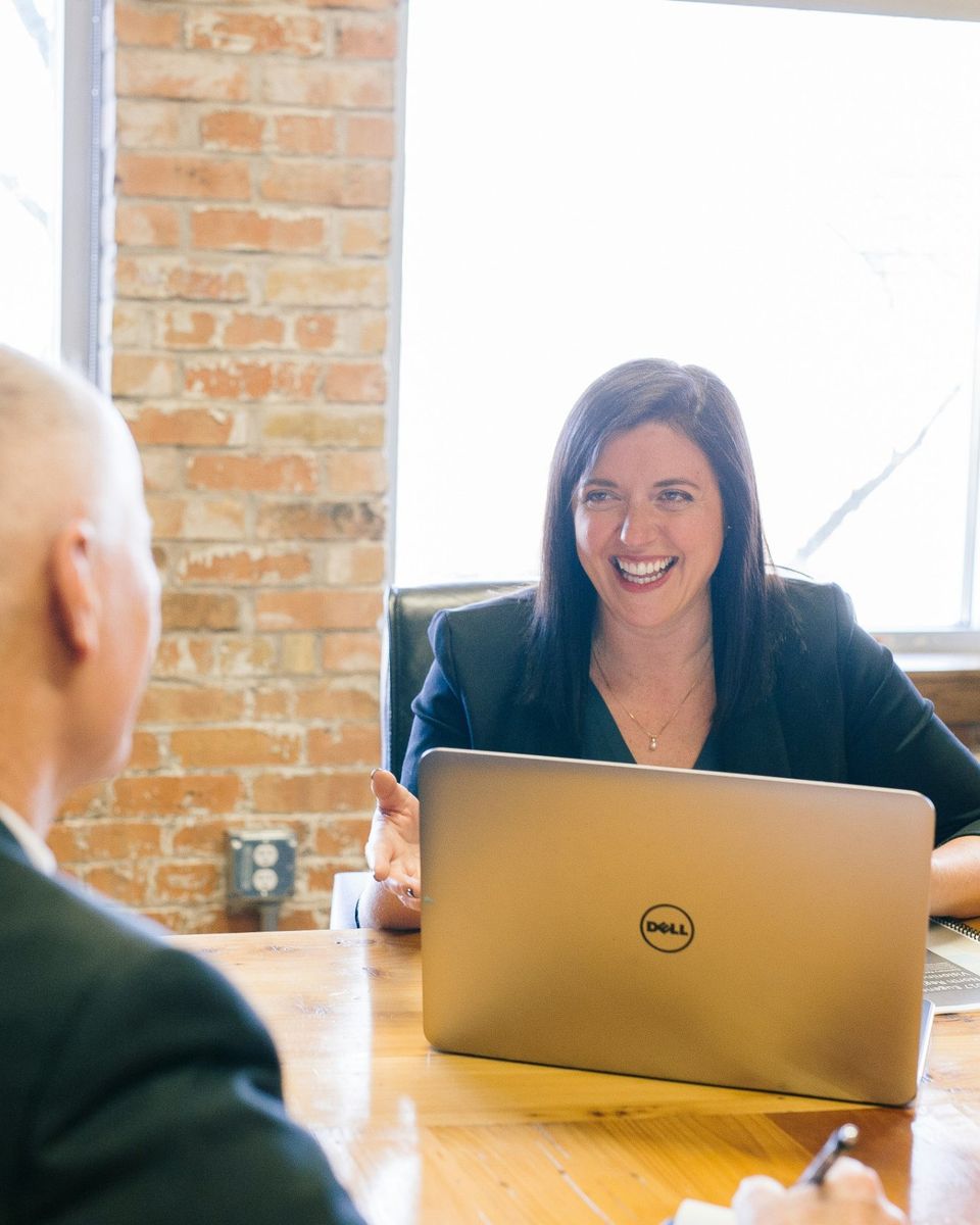 A smiling executive coach in a one-to-one conversation with a leader
