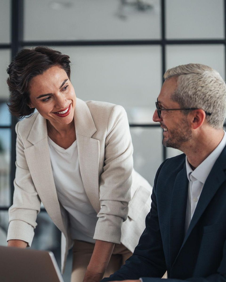 A senior HR leader advising an executive at his laptop